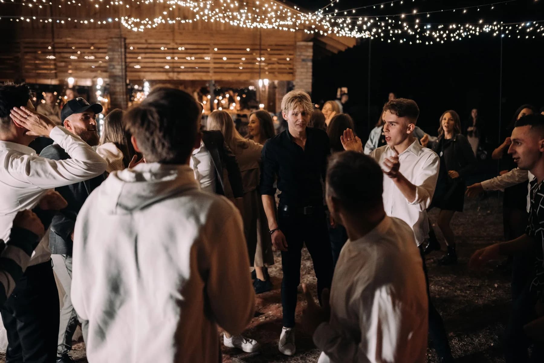 Adult guests dancing at an evening wedding reception
