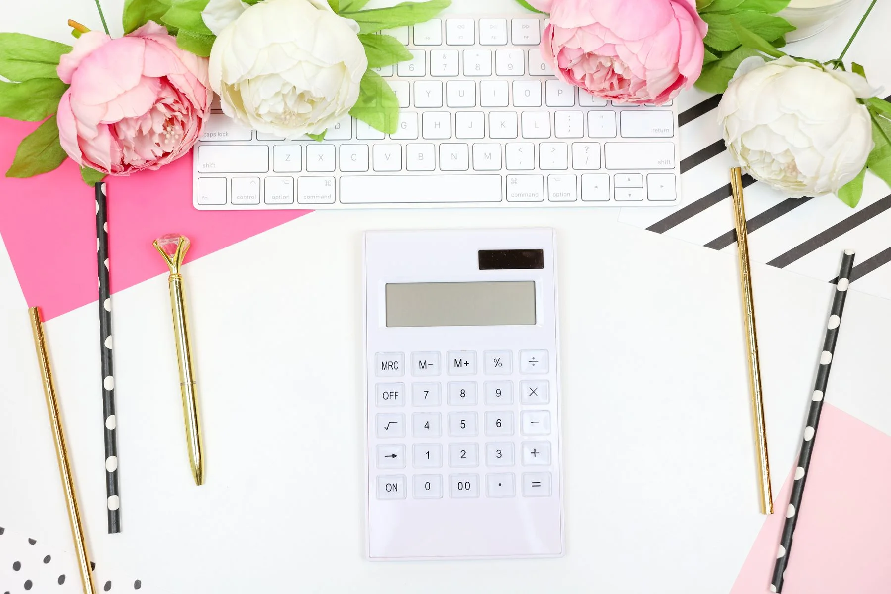 Taschenrechner, Notizblock und Blumen beim Planen des Hochzeitsbudgets