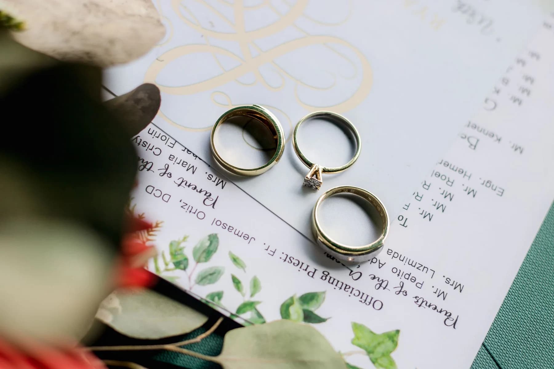 Drei Eheringe auf einer eleganten Hochzeitseinladung