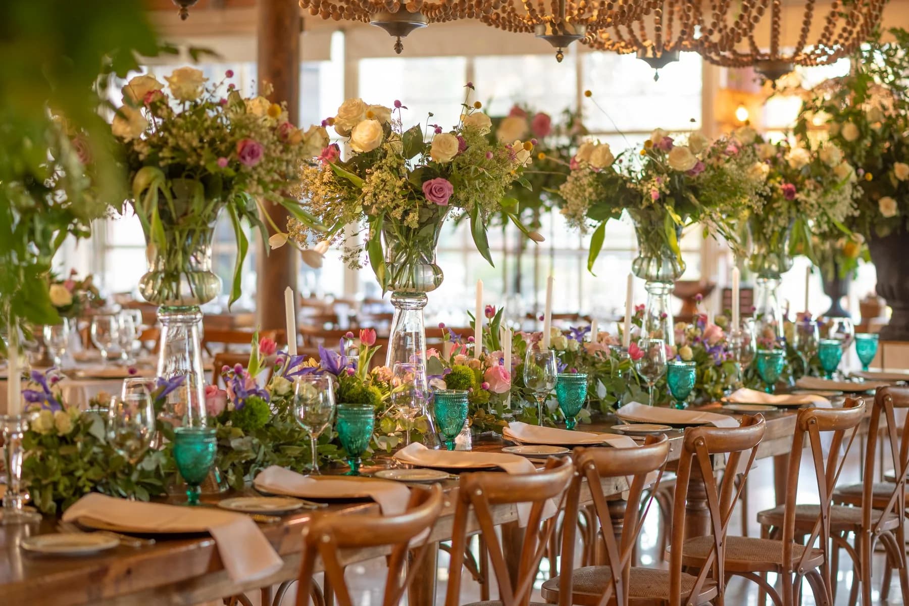 Mesa de boda colorida con flores ligeras y copas turquesas
